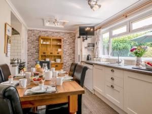 a kitchen with a wooden table with chairs around it at 3 Bed in Cantref BN363 in Brecon