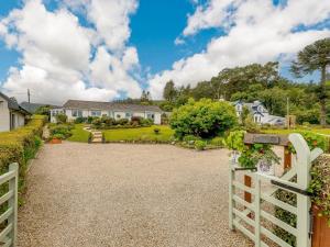a driveway leading to a house with a white fence at 1 Bed in Brodick CA308 in Brodick