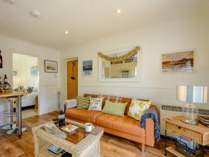a living room with an orange couch and a table at 1 Bed in Brodick CA308 in Brodick