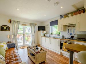 a kitchen with white cabinets and a couch in a room at 1 Bed in Brodick CA308 in Brodick