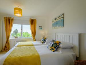 a bedroom with two beds and a window at 1 Bed in Brodick CA308 in Brodick