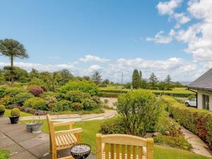 a park with two wooden benches and a garden at 1 Bed in Brodick CA308 in Brodick +10 photos