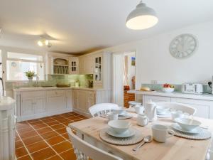 a kitchen with a wooden table and white cabinets at 3 Bed in Old Hunstanton 78821 in Hunstanton