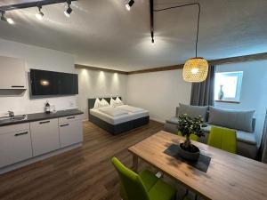 a living room with a bed and a table and a kitchen at Dolomitenblick Suite in Stronach