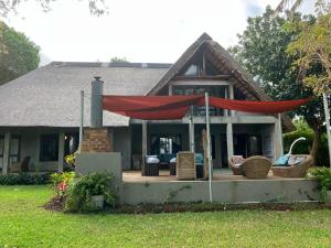 a house with a large red umbrella on a porch at Casa Jardim in Vilanculos