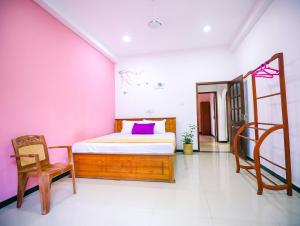 a bedroom with a bed and a ladder and a chair at Annasi Villa in Hikkaduwa