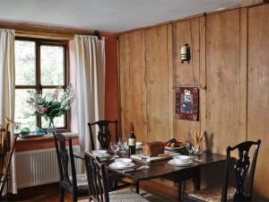 d'une salle à manger avec une table, des chaises et une fenêtre. dans l'établissement 1 Bed in Crickhowell BN144, à Llanbedr