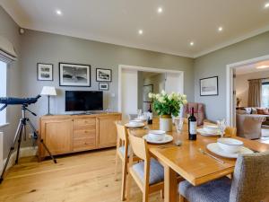 a dining room with a table and a television at 4 Bed in Llandudno 80288 in Rhôs-on-Sea