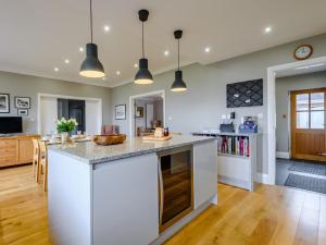 a kitchen with white counters and a large island at 4 Bed in Llandudno 80288 in Rhôs-on-Sea