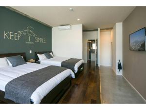 a hotel room with two beds and a sign that says keep it sane at ROI SPACE KAGOSHIMA - Vacation STAY 87818 in Kagoshima