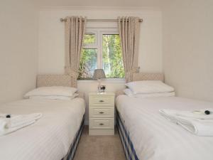 two twin beds in a room with a window at 2 Bed in Okehampton 80373 in Okehampton
