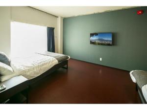 a bedroom with a bed and a green wall at ROI SPACE KAGOSHIMA - Vacation STAY 87819 in Kagoshima