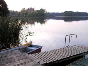 a dock on a lake with a house in the background at Ferienwohnung Haus am See in Ulrichshusen