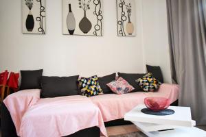 a living room with a pink couch with pillows at COZY BUNGLOW RINCONDA REAL in Benidorm