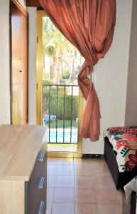 Schlafzimmer mit einer Tür zu einer Terrasse mit einem Fenster in der Unterkunft COZY BUNGLOW RINCONDA REAL in Benidorm