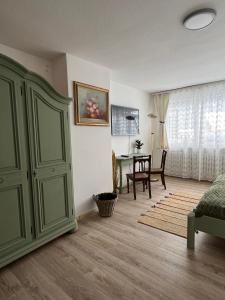 a living room with a green cabinet and a table at Haus zum guten Hirten in Steinsfeld