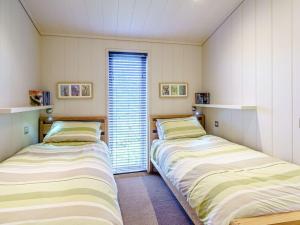 two twin beds in a room with a window at 2 Bed in Caldbeck 80562 in Caldbeck