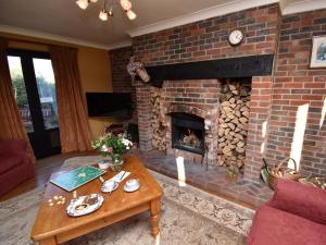 a living room with a brick fireplace and a table at 2 Bed in Winfrith Newburgh DC018 in Winfrith Newburgh