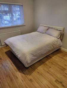 a bed in a bedroom with a wooden floor at Kent village house 