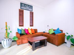 a living room with a couch with colorful pillows at Annasi Villa in Hikkaduwa