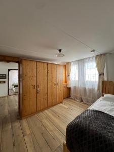 1 dormitorio con armarios de madera y 1 cama. en Haus zum guten Hirten, en Steinsfeld