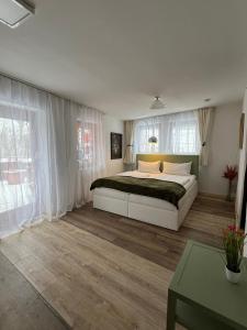 a bedroom with a large bed with white curtains at Haus zum guten Hirten in Steinsfeld