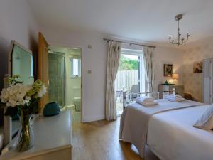 - une chambre avec un lit et un vase de fleurs sur une table dans l'établissement 2 Bed in Lulworth Cove DC170, à West Lulworth