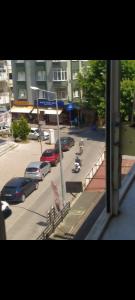 a view from a window of a street with parked cars at Akçay Kordon'da denize 40 metre in Akçay