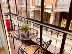 balcón con mesa, sillas y ventana en VUT Collado 28 Primero, en Soria