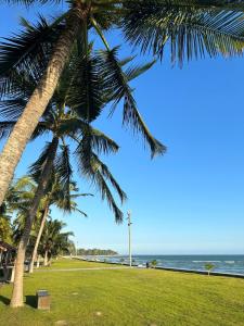 a view of the beach from under two palm trees at Dat Lanh Beach Resort in Lagi