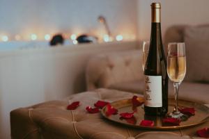 a bottle of wine and two glasses on a table at Luxury Jacuzzi Apartment in Mostar