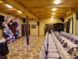 un salón de banquetes con mesas blancas, sillas y globos en Vila Dubysa, en Milašaičiai