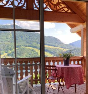 una mesa y sillas en un balcón con vistas en Ferienwohnungen Haus Rose Marie, en Grundlsee