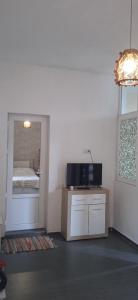 uma sala de estar com televisão e espelho em Гостевой дом в центре города em Kobuleti