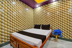 OYO Mohona Residency & Restaurant في Nimtita: غرفة نوم بسرير في غرفة بجدار