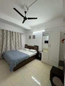a bedroom with a bed and a ceiling fan at La Belleza Guesthouse in Guwahati