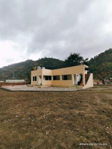 una casa está siendo construida en un campo en Gharonda Homestay, en Dogadda