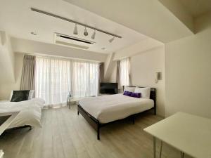 une chambre avec deux lits et une grande fenêtre dans l'établissement CASA VERDE Shinjuku# 1K, à Tokyo