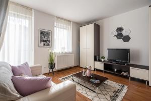 a living room with a couch and a tv at Harmony Hideaway Apartment in Budapest