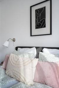 Schlafzimmer mit einem Bett mit rosa und weißen Kissen in der Unterkunft Harmony Hideaway Apartment in Budapest