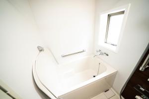 une salle de bain blanche avec une baignoire et une fenêtre dans l'établissement CASA VERDE Shinjuku# 1K, à Tokyo 21 autres photos
