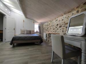ein Schlafzimmer mit einem Bett und einer Steinmauer in der Unterkunft Le Mas du Martinet in Anduze