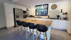 een keuken met een houten tafel en zwarte barkrukken bij Villa JELO - 2 Suites 2.5 Sdb Piscine & SPA* * * * in Saint Barthelemy