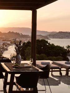 una mesa con copas de vino y vistas al océano en Ananta Blue Residence, en Argassi