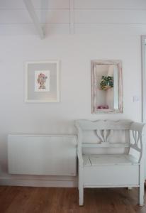 a white bench in a white room with a mirror at Mulberry Studio in Hawkhurst