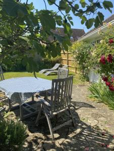 una mesa y sillas en un patio con una mesa en Mulberry Studio en Hawkhurst