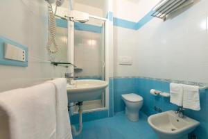 un bagno blu e bianco con lavandino e servizi igienici di Hotel Villa Ireos a Ischia