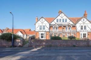 a large house with a brick fence in front of it at Gulls' Nest, Felixstowe in Felixstowe