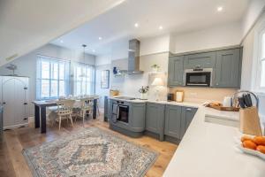 a kitchen with gray cabinets and a dining room at Gulls' Nest, Felixstowe in Felixstowe
