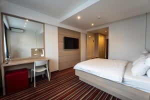 Habitación de hotel con cama y escritorio en Hotel Oscar en Campina